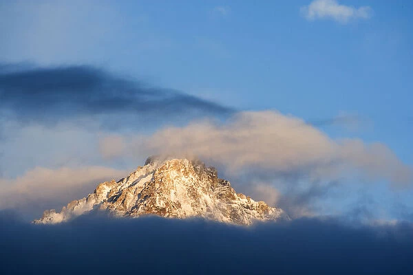 USA, Idaho, Sawtooth Range. Sunlit mountain and clouds