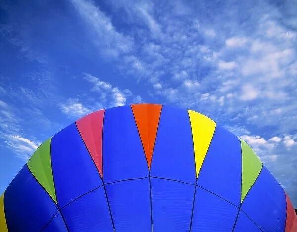 USA, Idaho, Teton Valley. A bright blue hot-air balloon floats over the Teton Valley