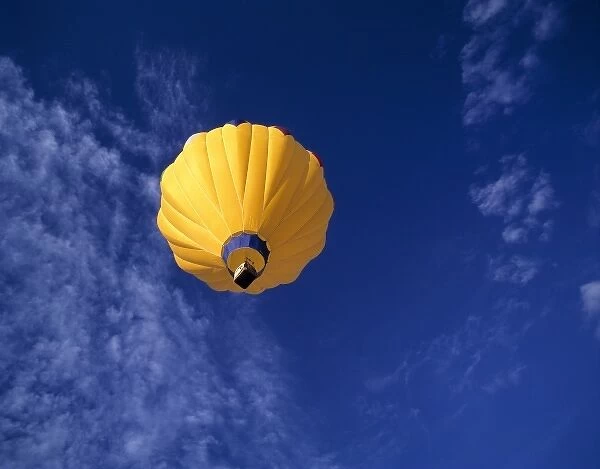 USA, Idaho, Teton Valley. A brilliant yellow hot-air balloon hovers over Teton Valley, Idaho