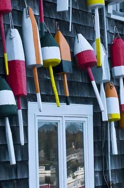 USA, Maine, Mount Desert. Hanging buoys with window reflection of Bernard Harbor