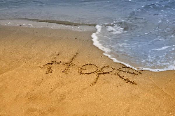USA, Maine, Phippsburg. The word hope carved in Popham Beach sand near surf. Credit as