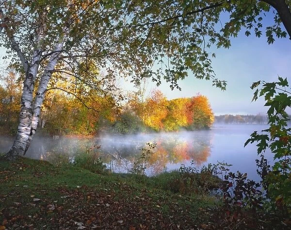 USA, Maine, Pittsfield. Morning sun and fog rising from Douglas Pond