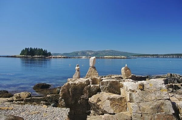 USA, Maine, Schoodic Peninsula. Stacked stones on top of rocks, calm ocean waters