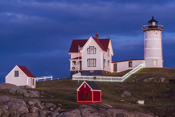 USA, Maine, York Beach, Nubble Light Lighthouse with Christmas decorations at dusk