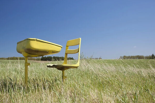 USA, Michigan, Hillman, Abandoned school desk and chairs in farmers field on spring
