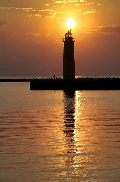 USA, Michigan, Muskegon. The setting sun silhouettes the lighthouse on Lake Michigan in Muskegon