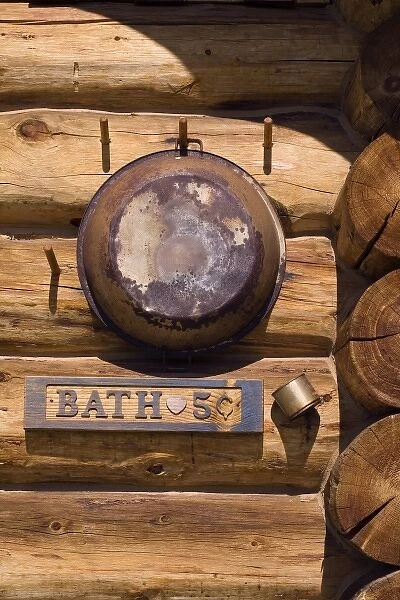 USA, Montana, Little Belt Mountains. Rusted pan and sign on outside of bath house
