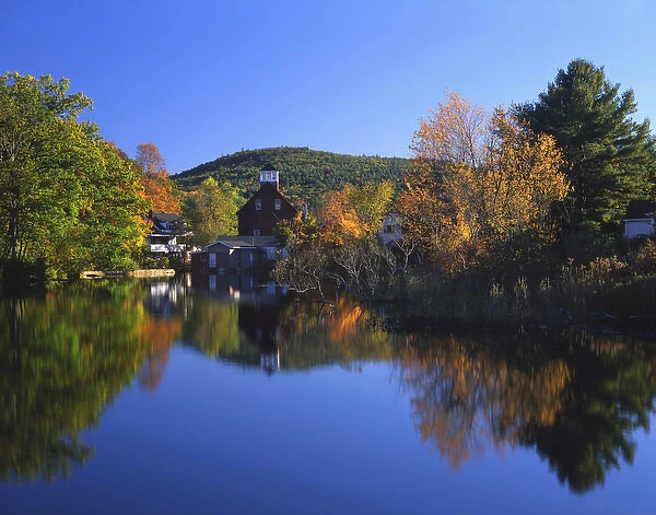 USA, New Hampshire, Ashland. Old grist mill building reflecting in pond. Credit as