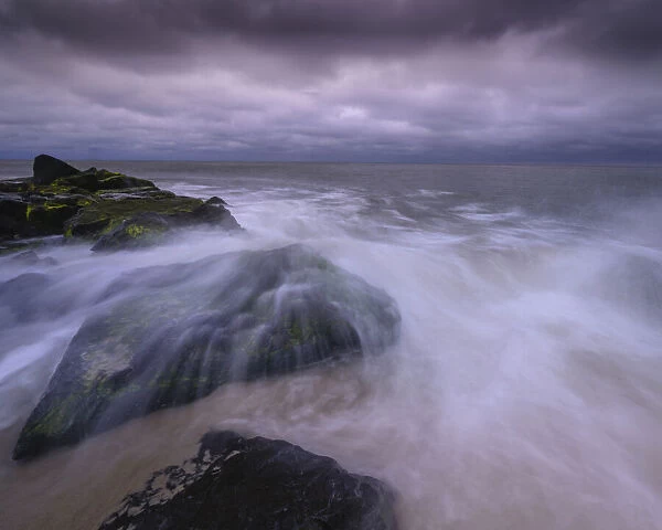 USA, New Jersey, Cape May National Seashore. Storm waves crash on rocks