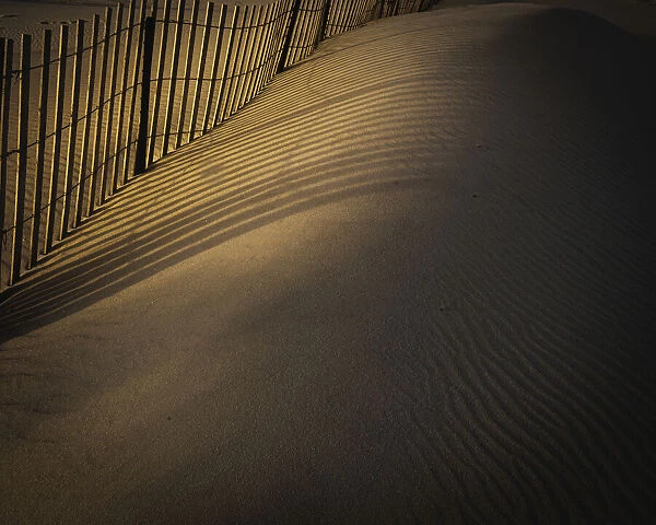 USA, New Jersey, Cape May National Seashore. Fence shadow patterns in sand