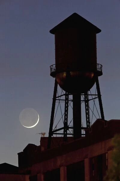 USA, New Jersey, Jersey City, Rooftop water tower and setting crescent moon