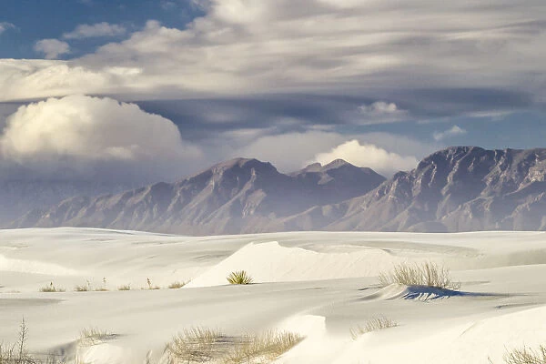 USA, New Mexico, White Sands National Monument. Clouds over mountains and sand. Credit as