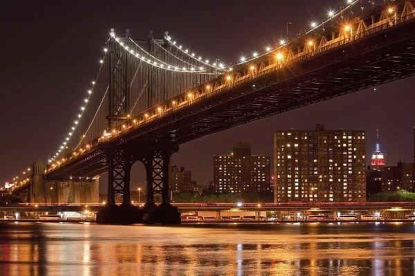 USA, New York, Brooklyn, Manhattan Bridge at night reflected in East River with Empire