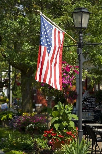 USA, New York, Lewiston. American flag attached to lamp post near wine shopFred J