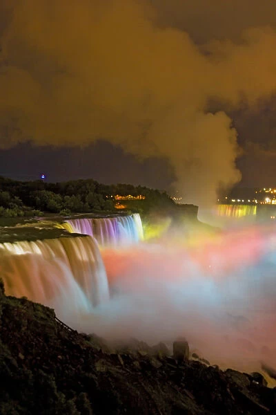USA, New York, Niagara Falls. Nighttime view of the waterfalls and mist lit with colored lights