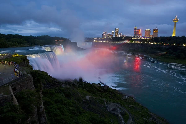 USA, New York, Niagara Falls. Tourists enjoy twilight view of American Falls in foreground