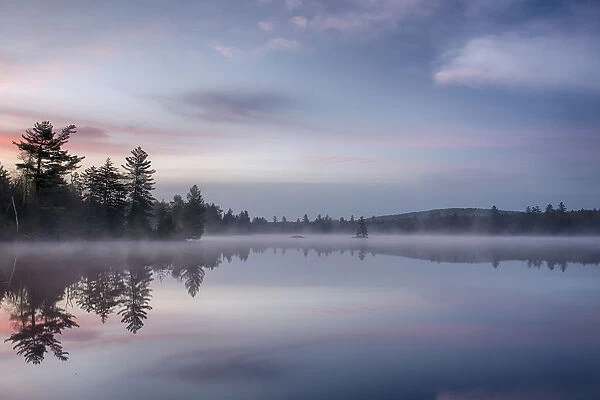 USA, New York State. Morning reflections on Lake Durant, Adirondack Mountains