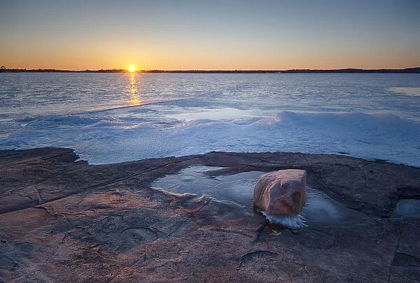 USA, New York State. Winter sunset over a frozen St. Lawrence River, Thousand Islands