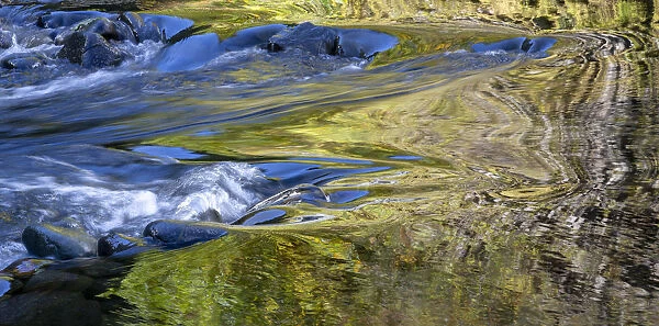 USA, Oregon. Abstract of autumn colors reflected in Wilson River rapids. Credit as