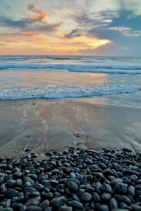 Framed Print : USA, Oregon, Arch Cape. Pacific coastline last evening light reflected in the sandy beach at low tide with foreground of shiny round black rocks