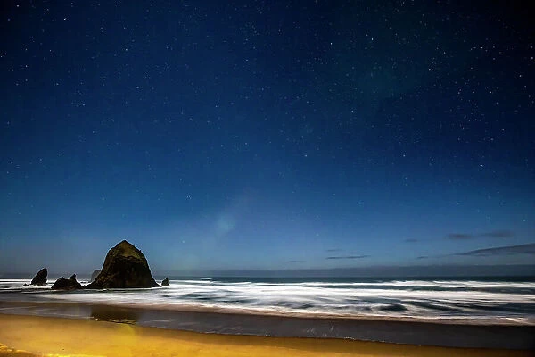 USA, Oregon. Cannon Beach and Haystack Rock stars showing during blue light