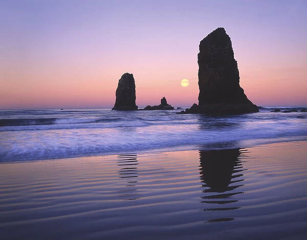 USA, Oregon, Cannon Beach, Moonset between The Needles rocks in early morning light
