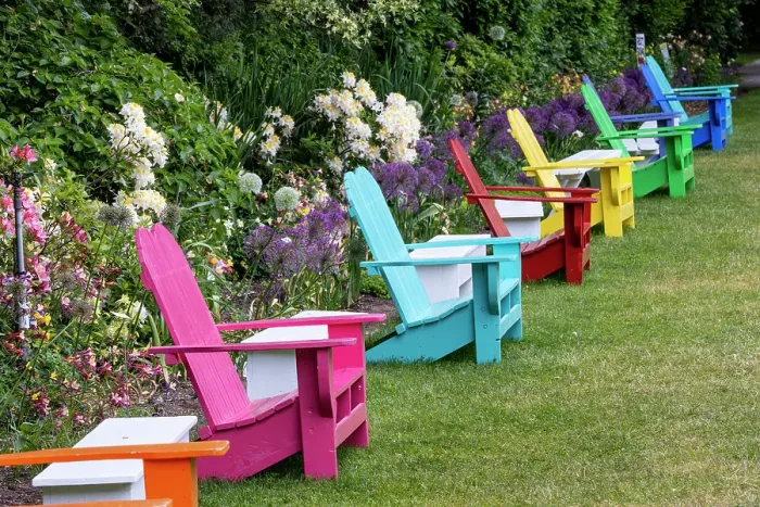 Framed Print : USA, Oregon. Garden in full bloom with row of colorful chairs amongst bearded iris and Russell lupine