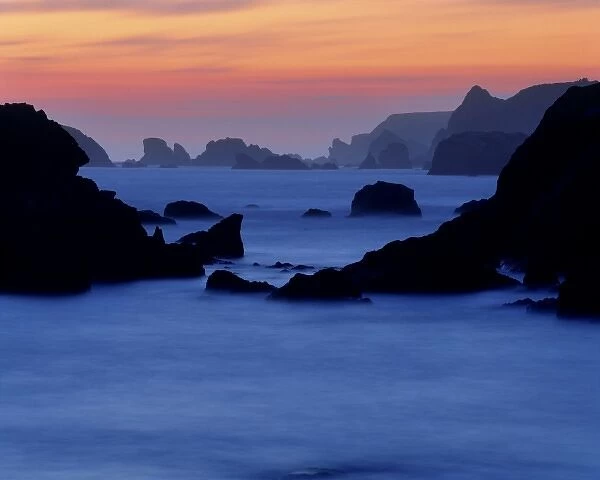 USA, Oregon, Harris Beach SP. A long exposure creates a misty effect at sunset at