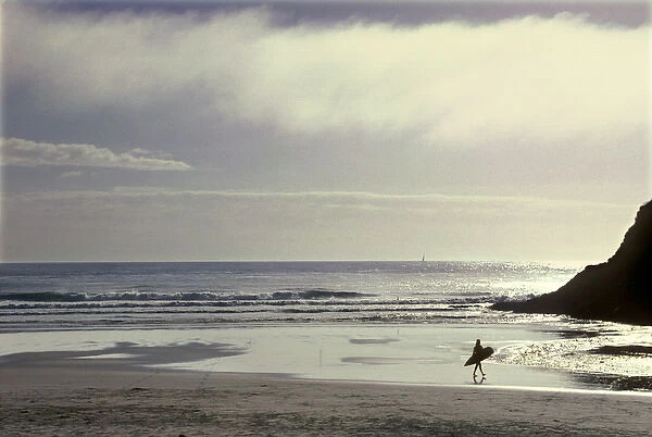 USA, Oregon, near Heceta Head, lone surfer going out into the Pacific Ocean