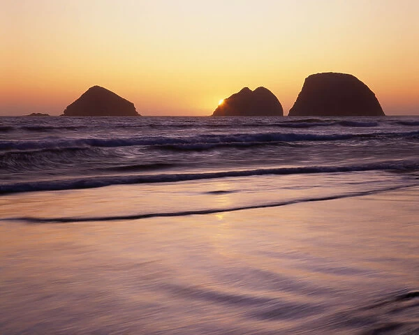 USA, Oregon, Oceanside Beach State Wayside. Sunset over Three Arch Rocks