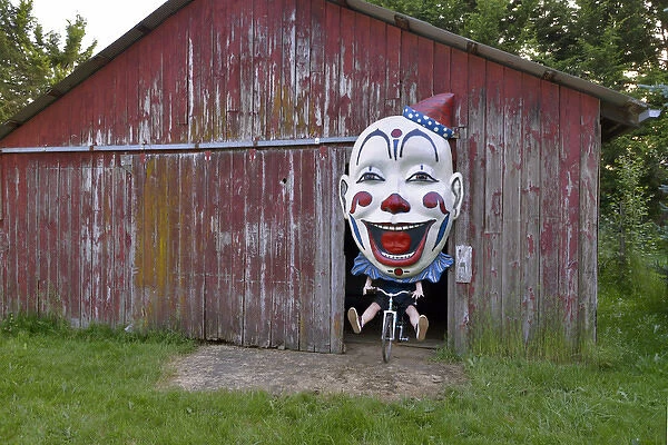 USA, Oregon, Oregon City. Clown face on bike in door of red barn
