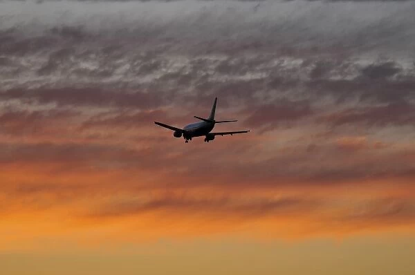 USA, Oregon, Portland. Airplane with landing gear down making a final approach to land at sunset
