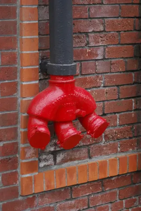 Framed Print : USA, Oregon, Portland. Bright red standpipe outside of brick building. Credit as Framed Print : USA, Oregon, Portland. Bright red standpipe outside of brick building. Credit as