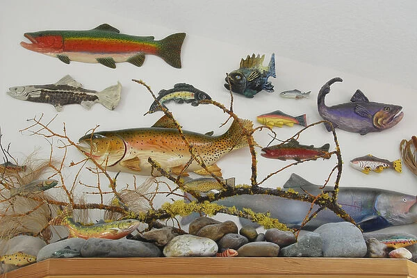 USA, Oregon, Portland. Eclectic collection of ceramic and wooden fish displayed on wall of home