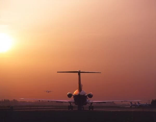 USA, Oregon, Portland, Jet passenger plane on runway at sunset at Portland International Airport