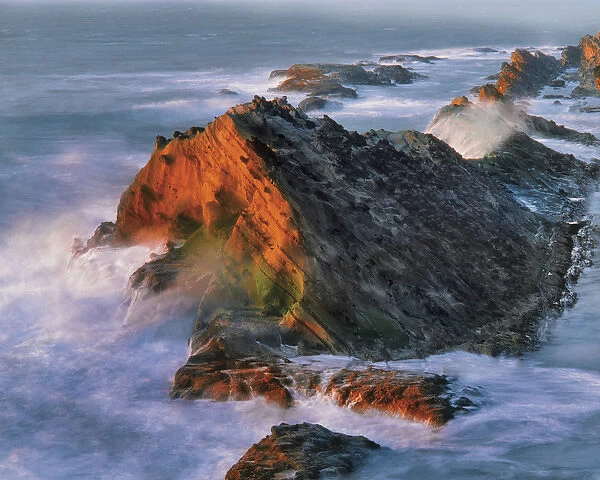 USA, Oregon, Shore Acres State Park. Sunset light on ocean shore cliffs. Credit as