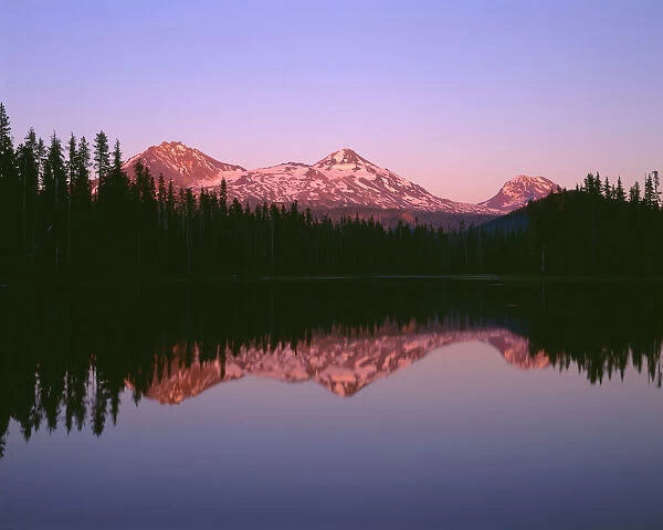 USA, Oregon, Willamette National Forest. Sunset reddens the Three Sisters (left to right: North