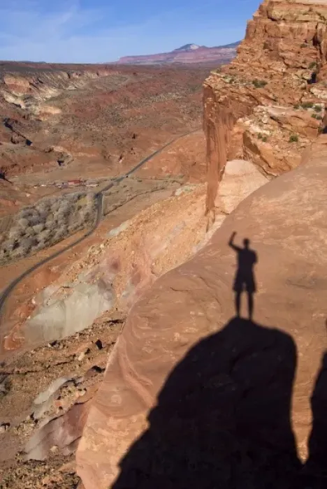 Framed Print : USA, Utah, Capitol Reef National Park. The shadow of a hiker standing on cliffs above the highway