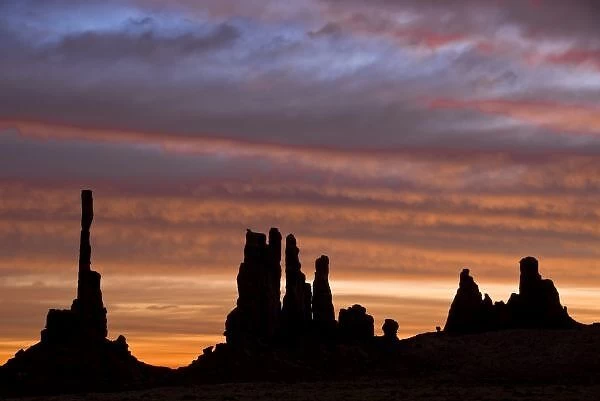 USA, Utah, Monument Valley National Park. Sunrise creates silhouettes of totem pole-like