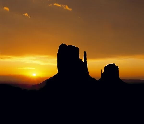 USA, Utah, Monument Valley. The North and South Mittens become silhouettes as the