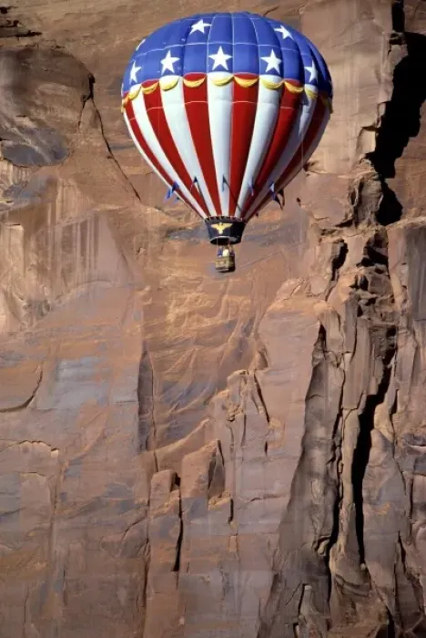 Framed Print : USA, Utah, Monument Valley. A patriotic hot-air balloon floats by a red rock wall Framed Print : USA, Utah, Monument Valley. A patriotic hot-air balloon floats by a red rock wall