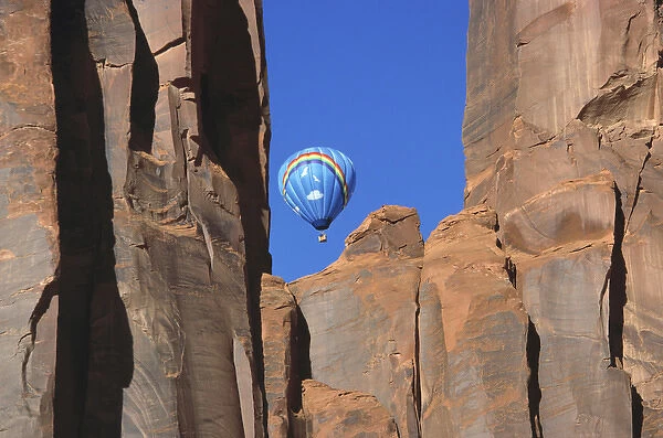 USA, Utah, Monument Valley. A rainbow hot-air balloon floats above Monument Valley, Utah