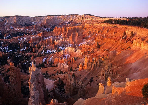 USA, Utah, Sun setting on Bryce Canyon, with snow clinging to the red cliffs