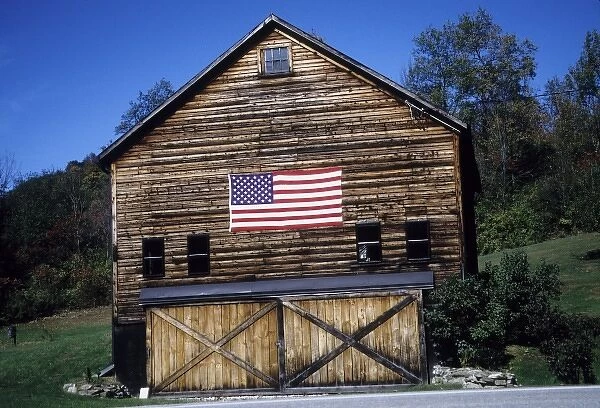 USA, Vermont. Log cabin with American flag on side