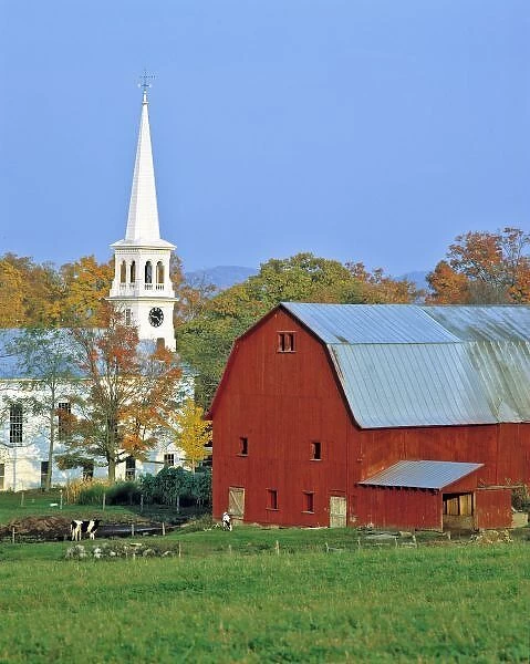 USA, Vermont, Peacham. A red barn and white church contrast with the green pasture in Peacham