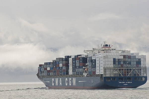 USA, WA, Laden container ship moves through Strait of Juan de Fuca with fog and clouds