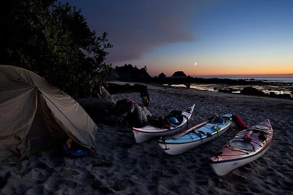 USA, WA, Olympic National Park. Sea kayaks and tent at kayaker camp, with crescent moon at sunset