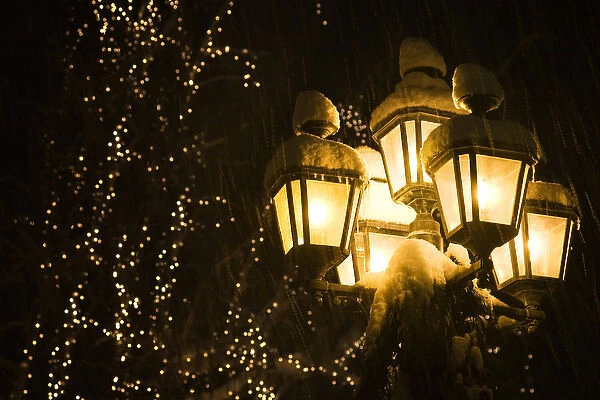 USA, Washington, Leavenworth. Snow-covered street lamps at night during Christmas holiday