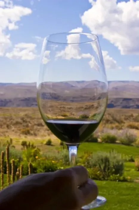 Framed Print : USA, Washington, Quincy. A sample of red wine in a glass overlooking Cave B Inn and Winery grounds Framed Print : USA, Washington, Quincy. A sample of red wine in a glass overlooking Cave B Inn and Winery grounds
