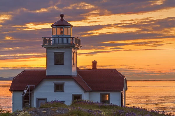 USA, Washington, San Juan Islands. Patos Lighthouse and camas flowers at sunset. Credit as